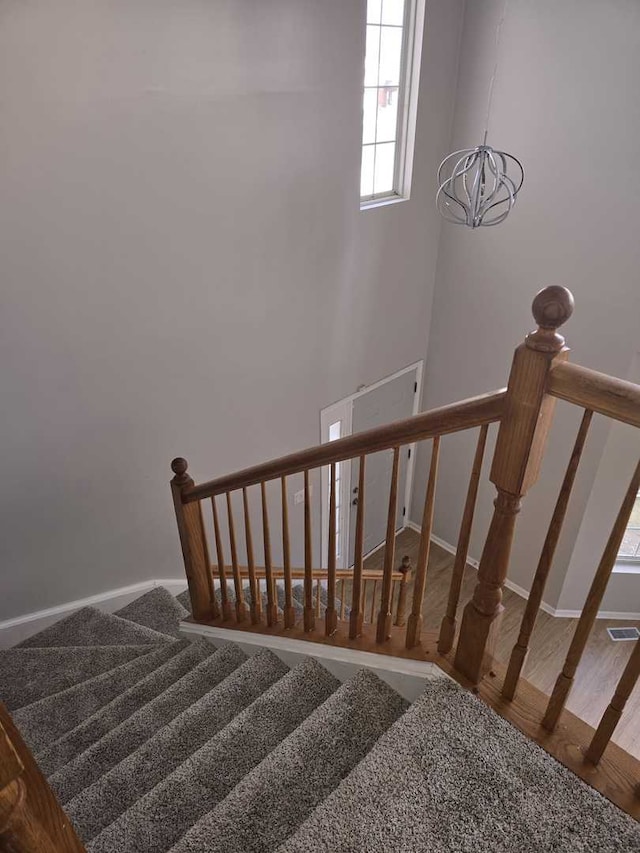 stairs featuring a chandelier