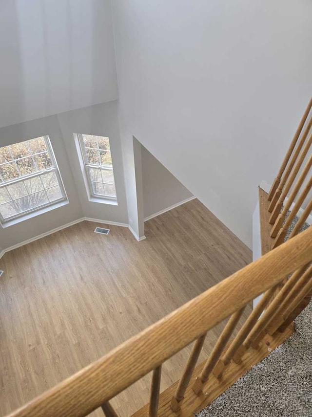 staircase featuring hardwood / wood-style floors and lofted ceiling