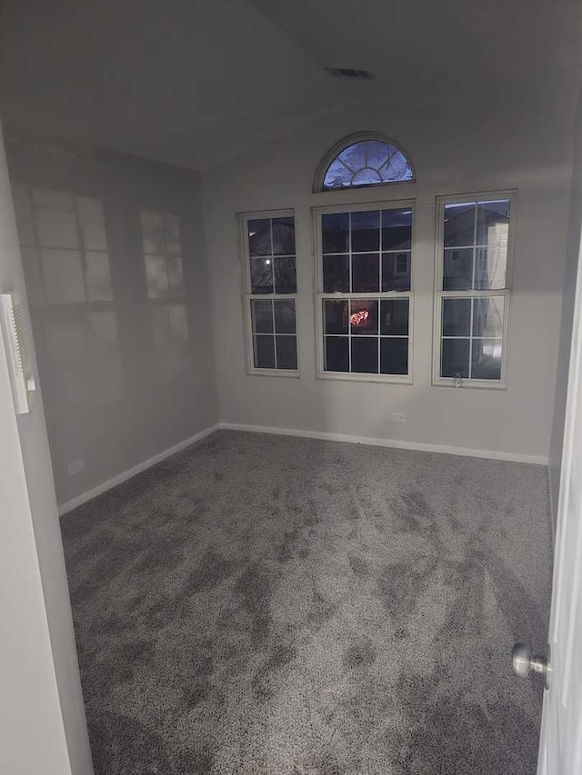 carpeted spare room featuring lofted ceiling