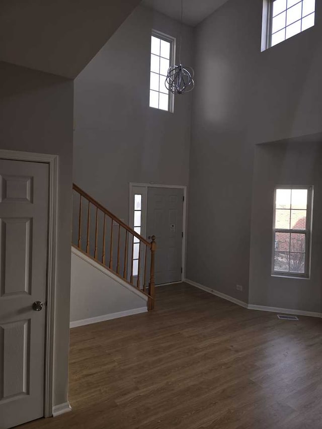 entryway featuring a chandelier, a high ceiling, and dark hardwood / wood-style floors