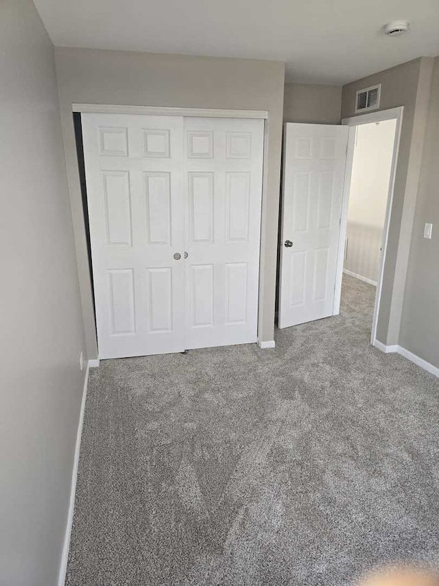 unfurnished bedroom with carpet and a closet