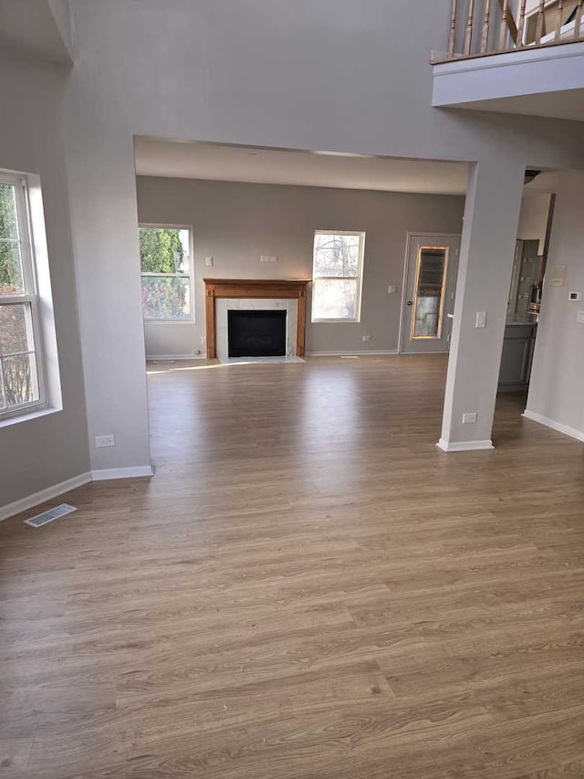 unfurnished living room with light hardwood / wood-style flooring and a healthy amount of sunlight