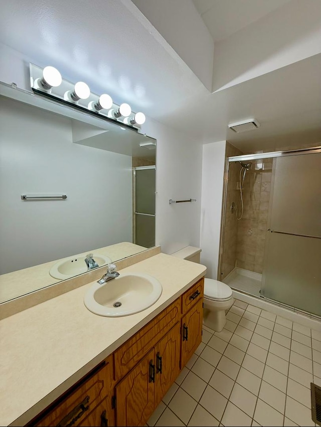 bathroom with tile patterned flooring, vanity, toilet, and an enclosed shower