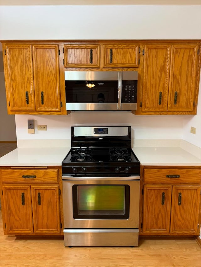 kitchen featuring stainless steel appliances and light hardwood / wood-style flooring