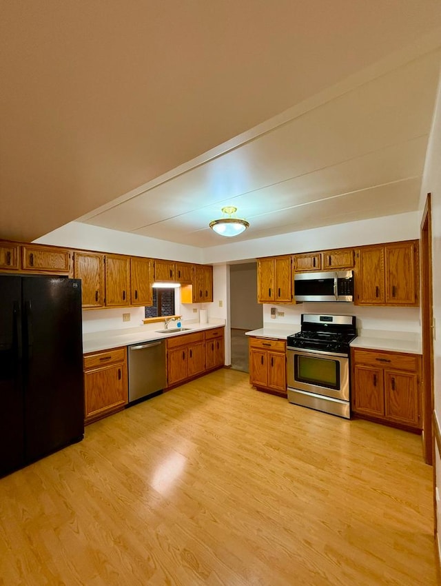 kitchen with sink, stainless steel appliances, and light hardwood / wood-style floors