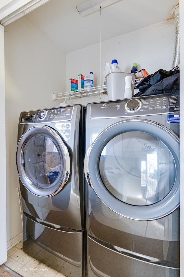 laundry room with washer and clothes dryer and tile patterned flooring