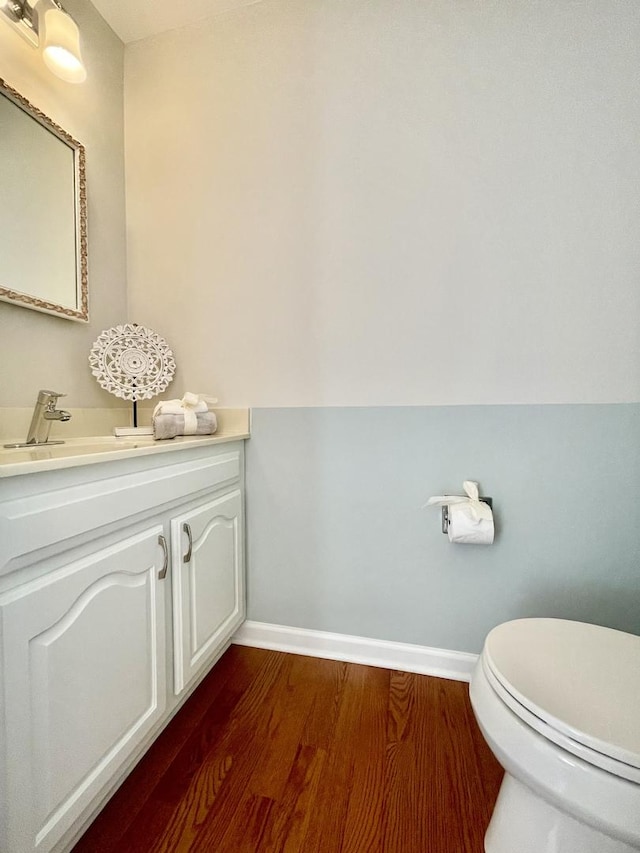 bathroom featuring vanity, wood-type flooring, and toilet