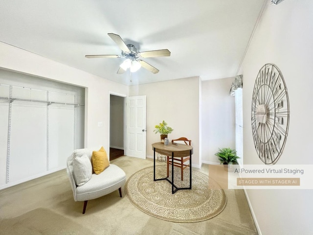 sitting room with light colored carpet and ceiling fan