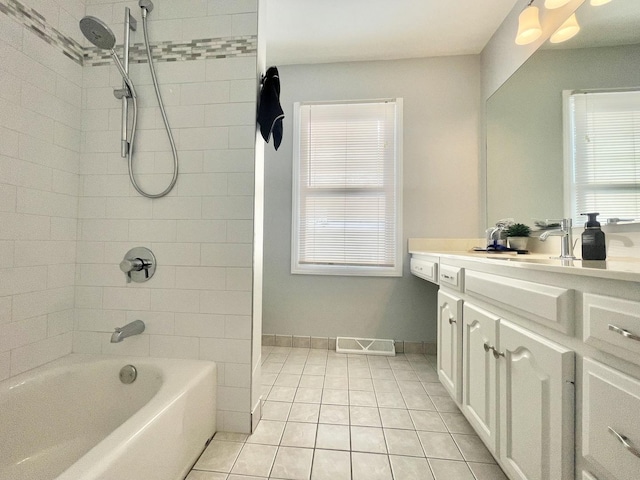 bathroom featuring tile patterned flooring, vanity, and tiled shower / bath combo