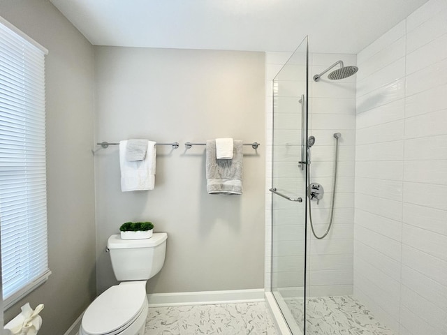 bathroom with a tile shower and toilet