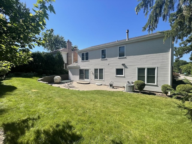 back of house featuring a lawn, a patio, and central air condition unit