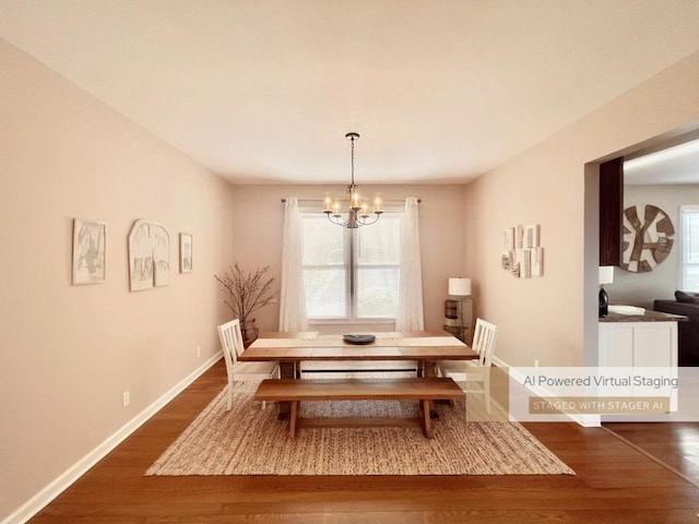 dining area with a notable chandelier and dark hardwood / wood-style flooring