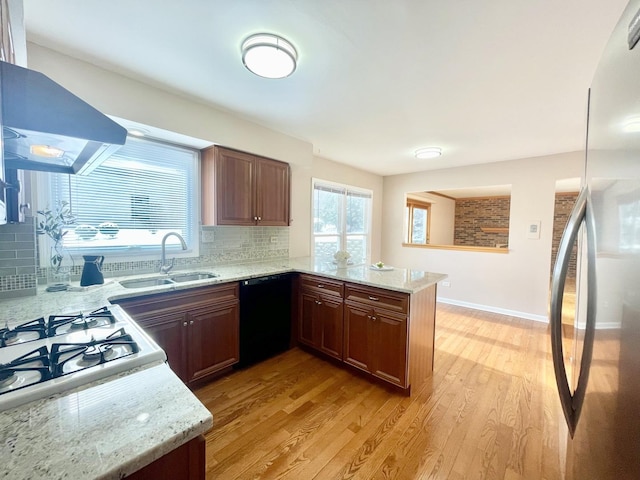 kitchen with fridge, dishwasher, kitchen peninsula, and light wood-type flooring