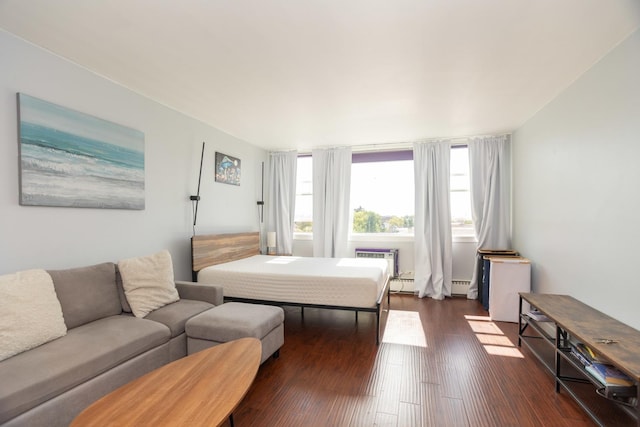 bedroom featuring baseboard heating and dark hardwood / wood-style floors