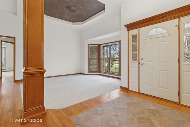 entrance foyer with light wood-type flooring and a tray ceiling