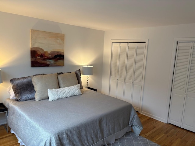 bedroom with multiple closets and hardwood / wood-style floors