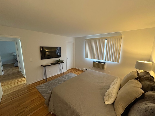 bedroom featuring a wall mounted AC and hardwood / wood-style floors