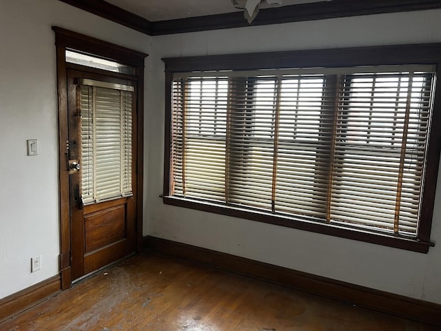 spare room with hardwood / wood-style flooring, a healthy amount of sunlight, and ornamental molding