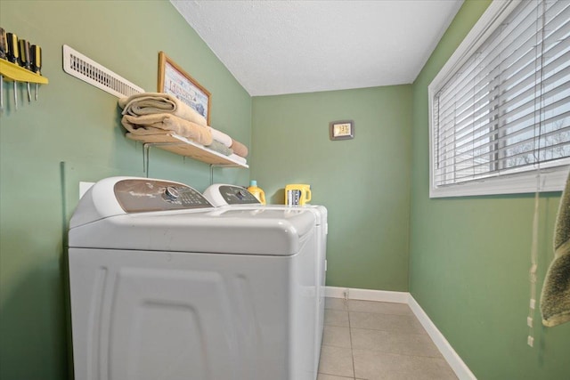 laundry room with independent washer and dryer, a textured ceiling, and light tile patterned floors