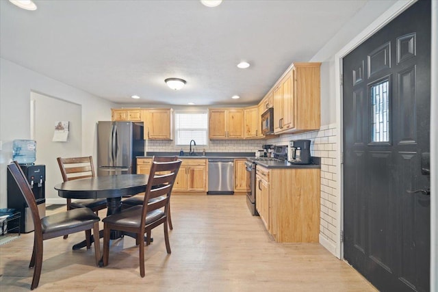 kitchen featuring light brown cabinets, backsplash, sink, light wood-type flooring, and stainless steel appliances