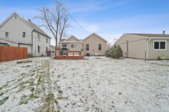 snow covered rear of property featuring a deck