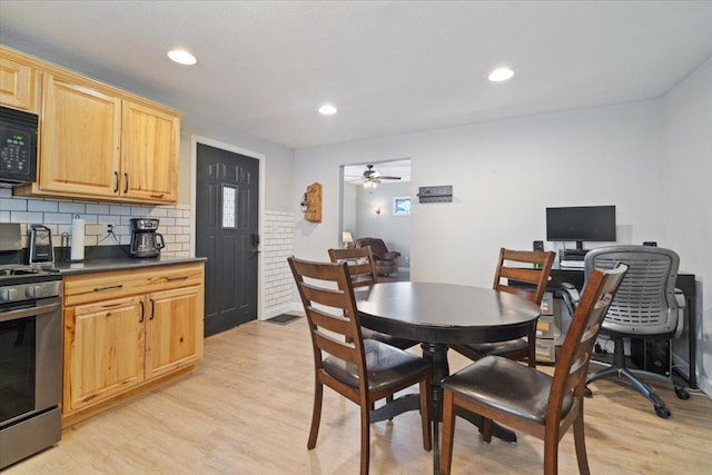 dining area with light hardwood / wood-style floors and ceiling fan