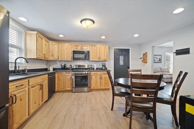 kitchen featuring decorative backsplash, sink, black appliances, light brown cabinets, and light hardwood / wood-style floors