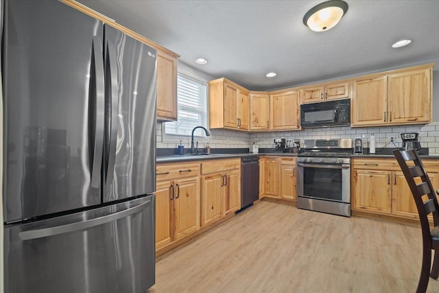 kitchen with decorative backsplash, sink, stainless steel appliances, and light hardwood / wood-style floors