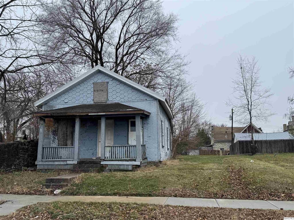 bungalow-style house featuring covered porch and a front yard