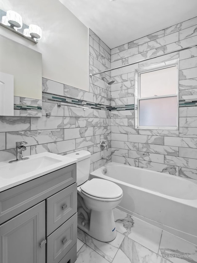 full bathroom featuring tiled shower / bath, vanity, toilet, and tile walls