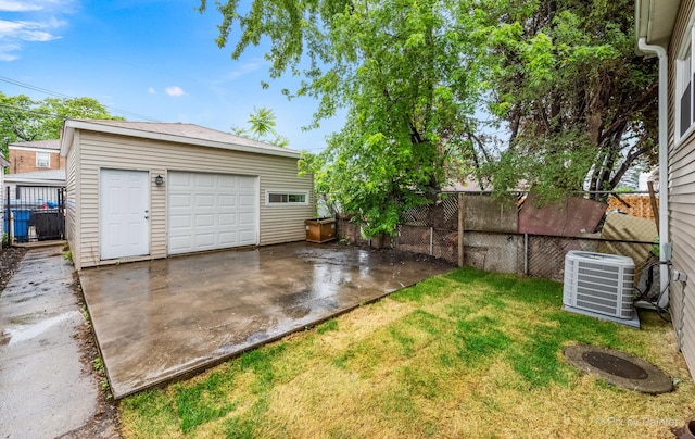 view of yard featuring a garage, an outbuilding, and central AC