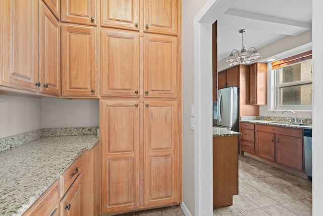 kitchen featuring light stone countertops, sink, a notable chandelier, decorative light fixtures, and appliances with stainless steel finishes