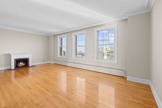 unfurnished living room featuring light hardwood / wood-style floors, crown molding, and a baseboard heating unit