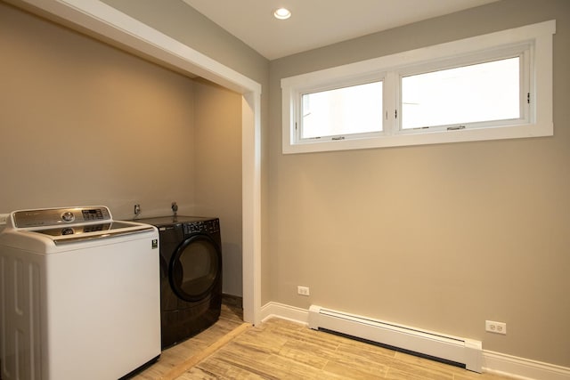 clothes washing area with a baseboard heating unit, light hardwood / wood-style floors, and washing machine and clothes dryer