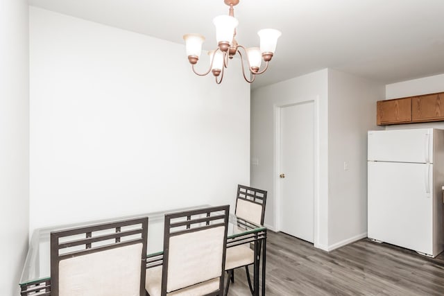 dining space featuring hardwood / wood-style floors and a chandelier