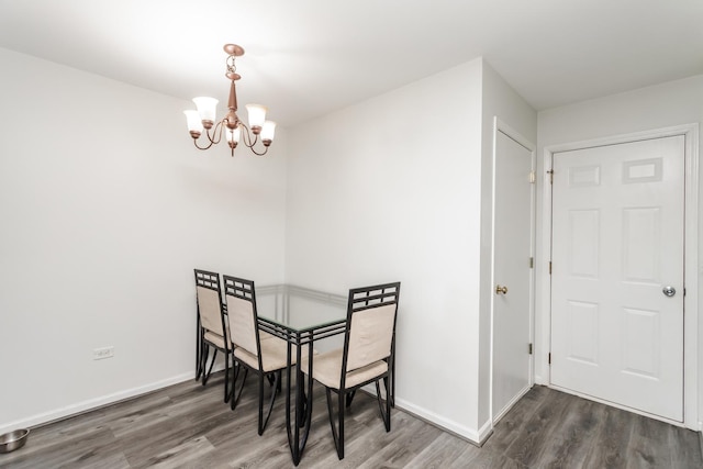 dining space featuring dark wood-type flooring and a chandelier