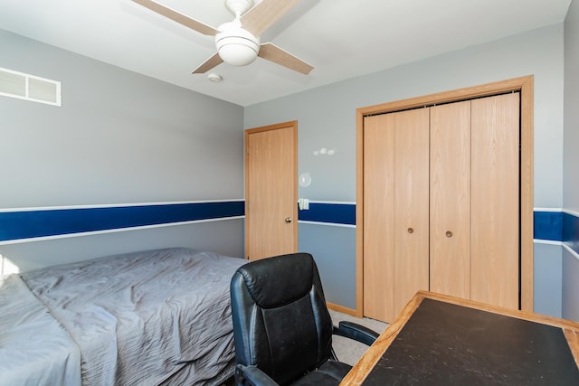 carpeted bedroom featuring ceiling fan and a closet