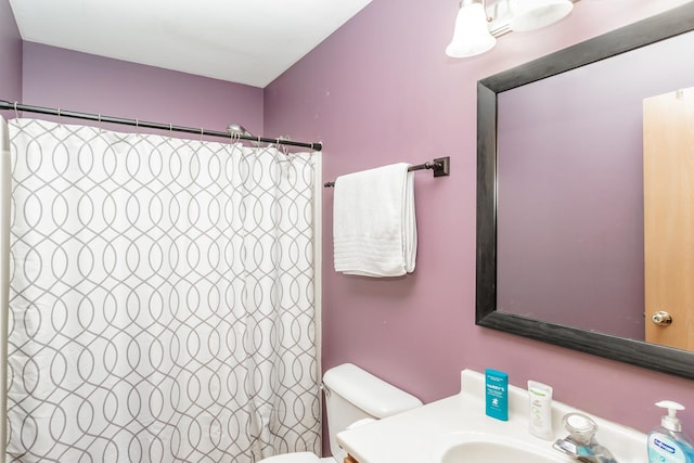 bathroom featuring vanity, toilet, and curtained shower