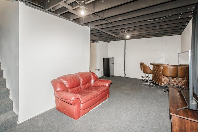 basement with dark colored carpet, stainless steel fridge, and bar