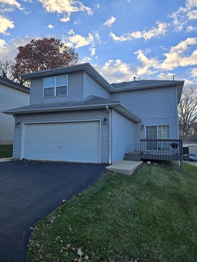 front of property featuring a front yard, a deck, and a garage