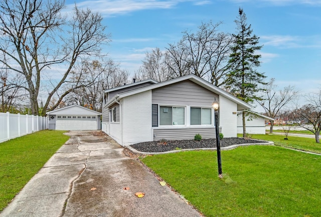 single story home with a front lawn, an outdoor structure, and a garage