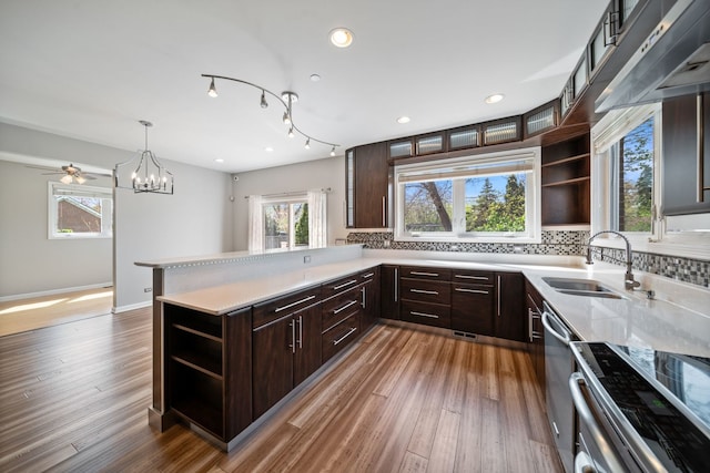 kitchen with a sink, open shelves, stainless steel range with electric stovetop, and dark brown cabinets
