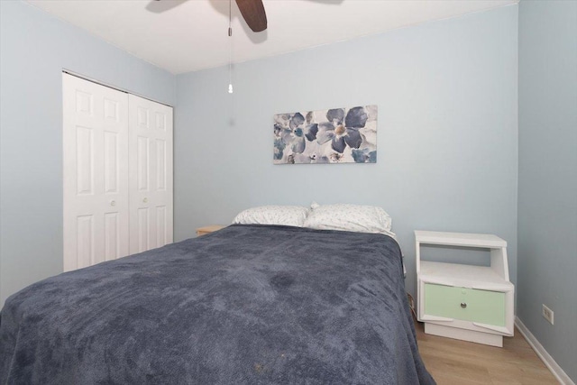 bedroom with hardwood / wood-style flooring, a closet, and ceiling fan