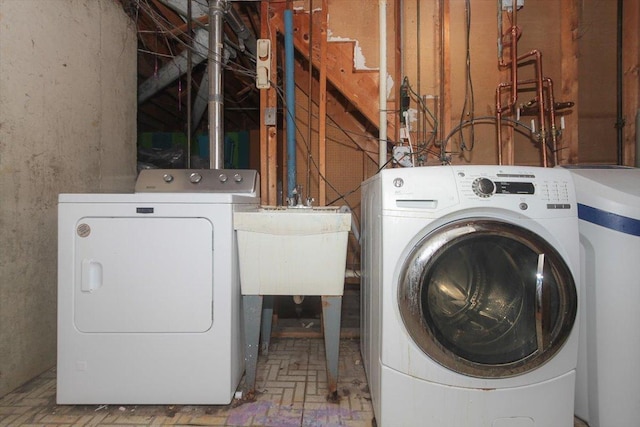 laundry area with independent washer and dryer and sink