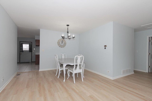 dining area featuring an inviting chandelier and light wood-type flooring