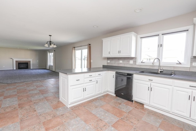 kitchen with white cabinetry, sink, black dishwasher, backsplash, and kitchen peninsula