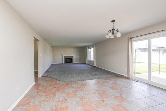 unfurnished living room with a notable chandelier and light colored carpet