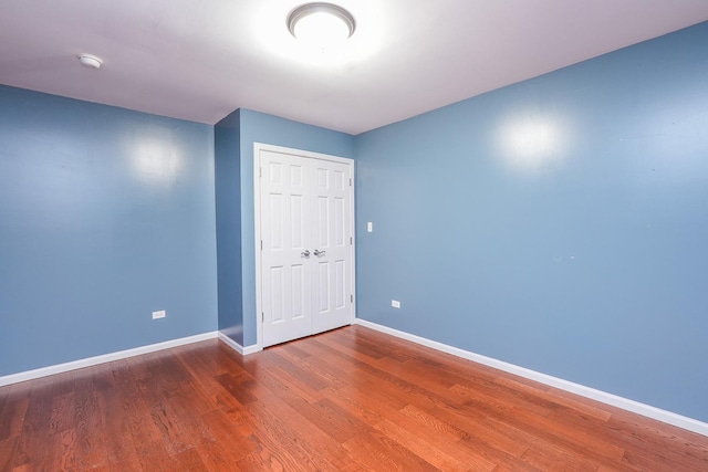 unfurnished bedroom with a closet and wood-type flooring