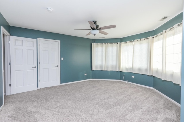 empty room with ceiling fan and carpet