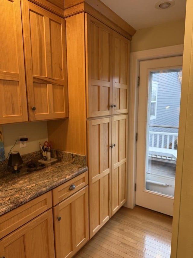 kitchen with dark stone counters and light wood-type flooring